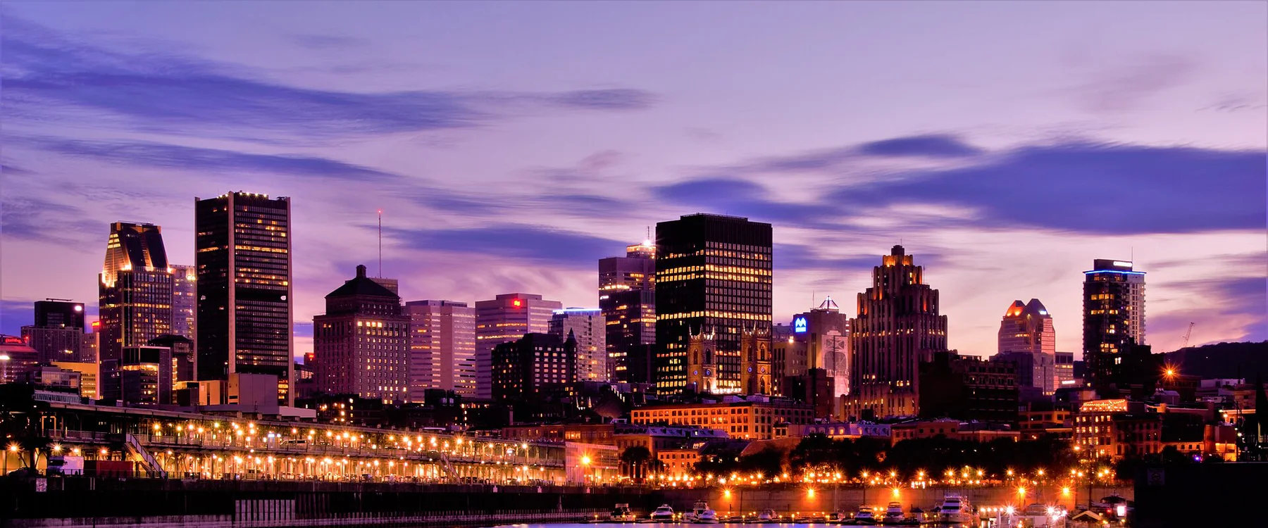 Montreal skyline glowing above the waterfront at dusk
